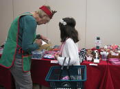 A volunteer helps a child with her shopping list at the Holiday Store.