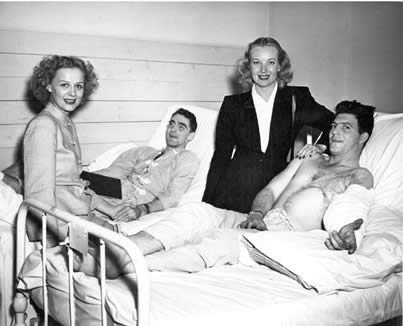 Movie starlets Gloria Stuart and Hillary Brooke visit with two convalescing 