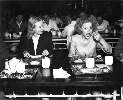Gloria Stuart and Hillary Brooke eat with patients and staff in a hospital 