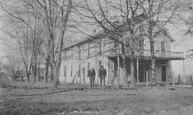 The Simons Hotel. William Jennings Bryan made a speech from the hotel balcony in the presidential campaign of 1896. The photograph, taken about 1915, shows the Rev. Tom Bird, Melvin Bird, and Lee Bird. Melvin and his wife operated the hotel for several years. The old buitding will soon be torn down.