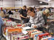A woman flips through a book in the cookbook section at the Friends of the Library Book Sale.