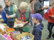 A volunteer and young boy shop for gifts together at the Holiday Store.