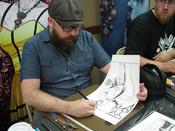 Comics artist Kyle Strahm works on a sketch during LibraryCon 2017.