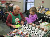  A volunteer helps a child shop at the Holiday Store.