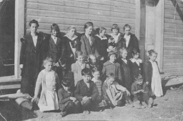 STAR SCHOOLHOUSE about 1915, Blue Eye's first school. The teacher, Miss Audie O'Neil, is standing in the back row, left. Next to her is Zelpha Kearns, and the girl who is second from the extreme right is believed to be Jewell Butler. The young ladies at the extreme right and left of the first row are Elsie Kearns and Nora Carr. The frame schoolhouse was replaced about 1922 with a new building.