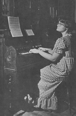 Museum staff member, Jeane Myer, at keyboard of the Cornish parlor organ.  Contributed by Mr. Ralph Foster, and Mrs. Bertha Youngblood, in loving memory of William V. and Pauline A. Holbrook.
